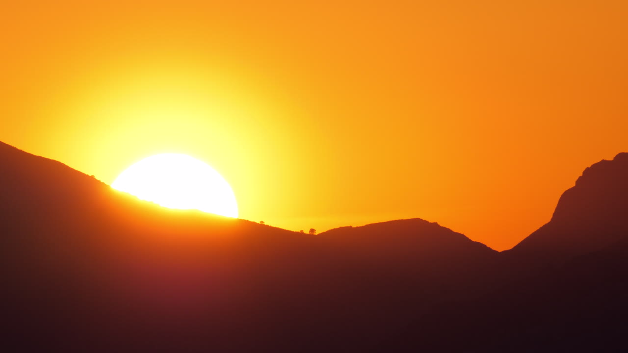 заходящее солнце за горной скалой