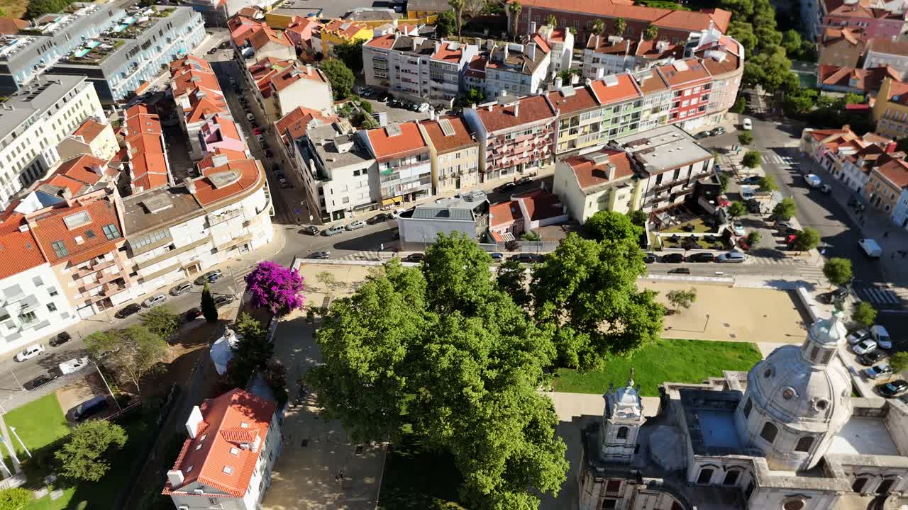 Aerial view of a historic European town with a prominent church, green spaces, and traditional buildings
