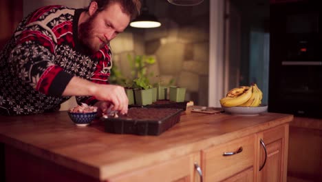 a man is cultivating garlic by placing it in soil within a compact rectangular container - static shot