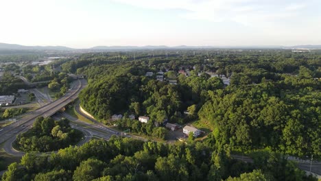 drone shot flying over trees reviling street and highway 24fps