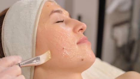 professional face care procedures in the modern cosmetology clinic. beautician is doing face treatment procedures - purification, mask, peeling, carboxytherapy