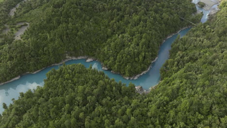 Winding-azure-colored-river-through-green-forest-landscape,-Hokitika-Gorge