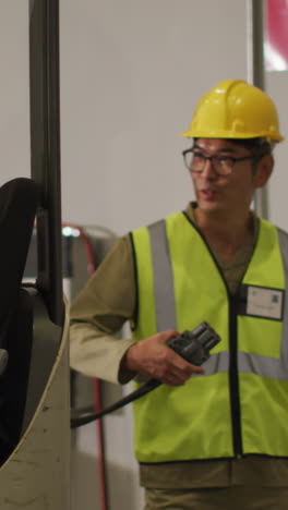 diverse male workers wearing safety suits and sitting in turret truck in warehouse