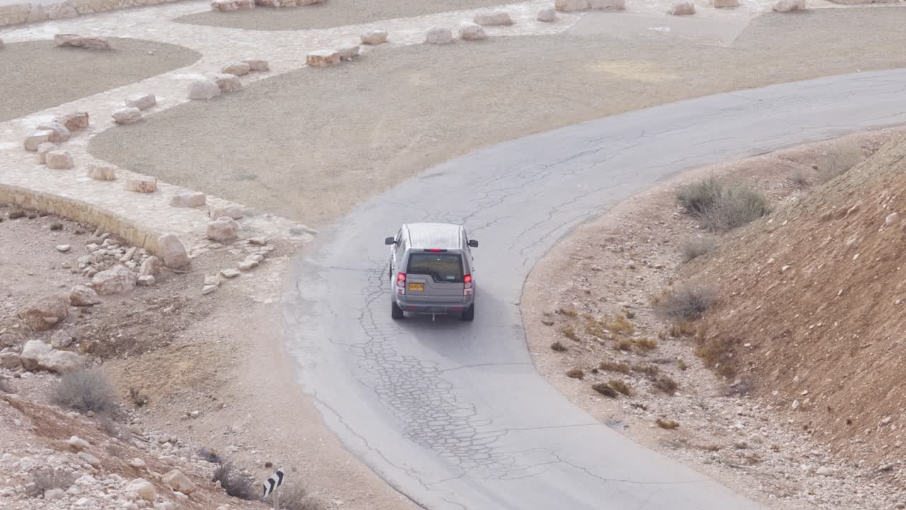 Una jeep, un SUV che scende su una strada curva nel deserto