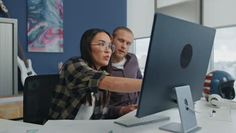 Serious programmers discussing computer at modern office. Managers sharing ideas