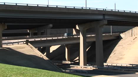 a pan shot of cars driving over a freeway overpass