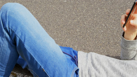 close-up of smiling young caucasian man using mobile phone at countryside road in the sunshine 4k