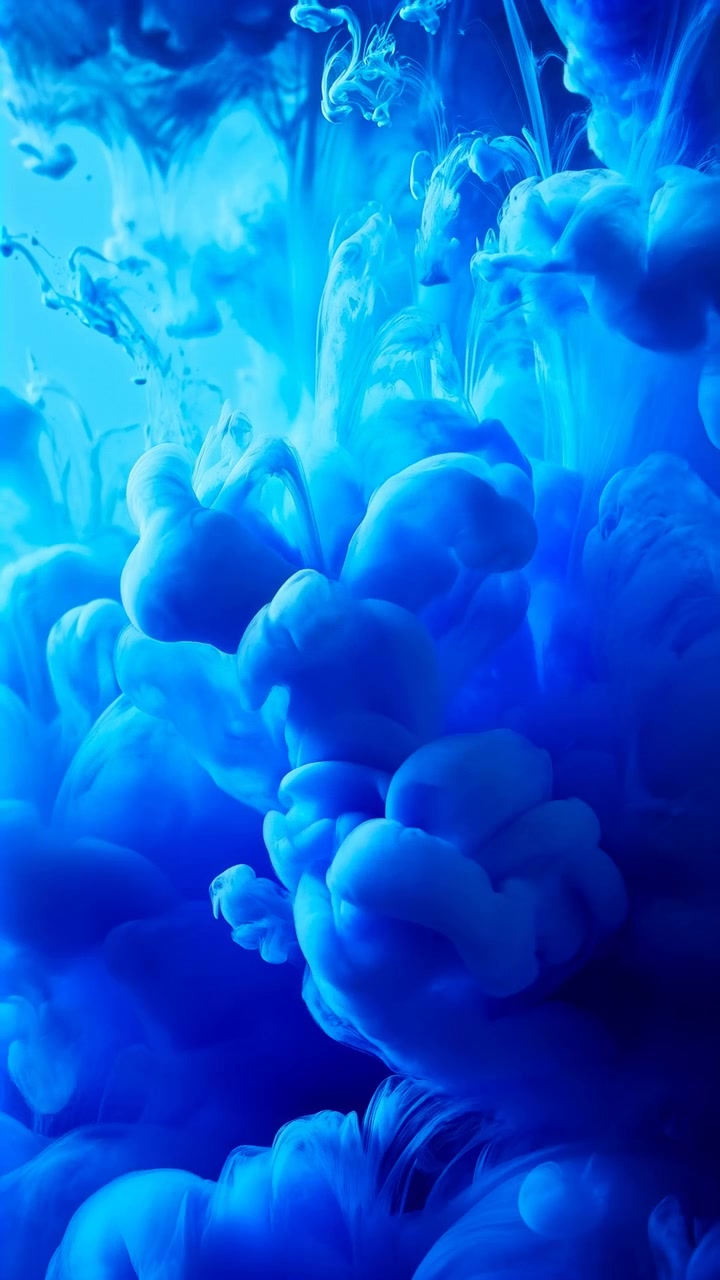 Pigmento blu denso sospeso in un liquido crea nuvole ondeggianti e viticci che salgono, con lobi più piccoli che si separano lungo i bordi, filamenti sottili, punti luce soffusi, ricche sfumature ciano e una superficie liscia.