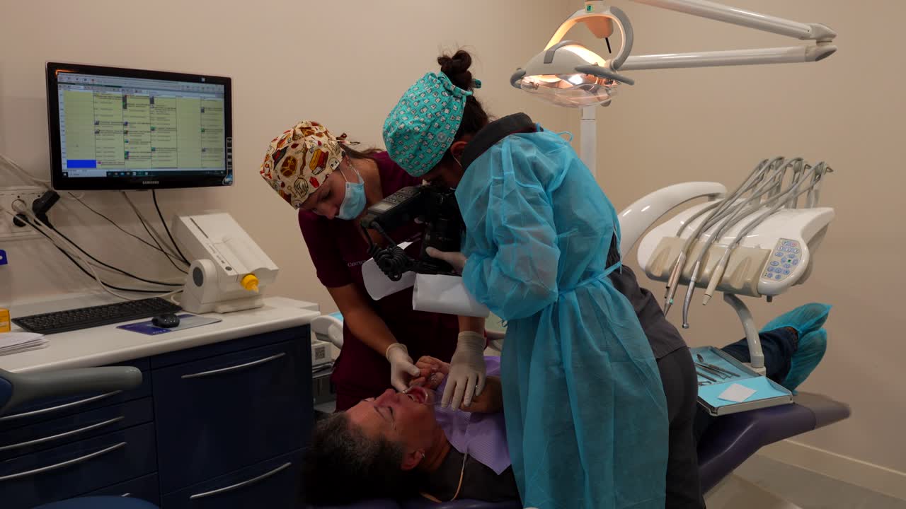 Dentist takes a photo of a patient's teeth using digital camera