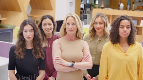 Retrato-De-Un-Equipo-Empresarial-Femenino-Multicultural-De-Pie-En-Una-Oficina-Moderna-Y-Abierta