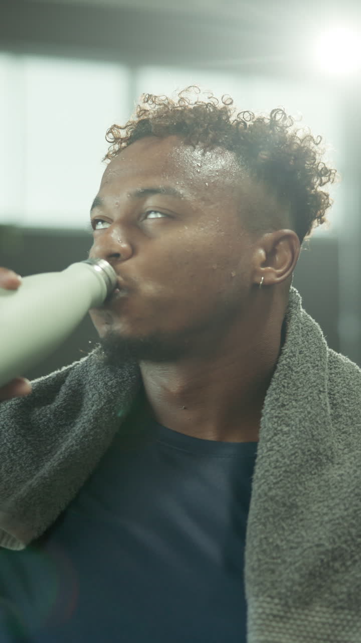 Sweaty Man Drinks Water from Bottle After Intense Workout