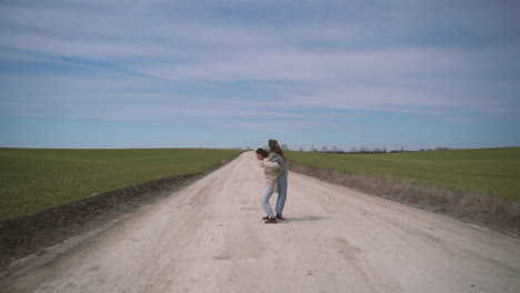 two young girls playing teeter totter in the middle of a lost road in the countryside