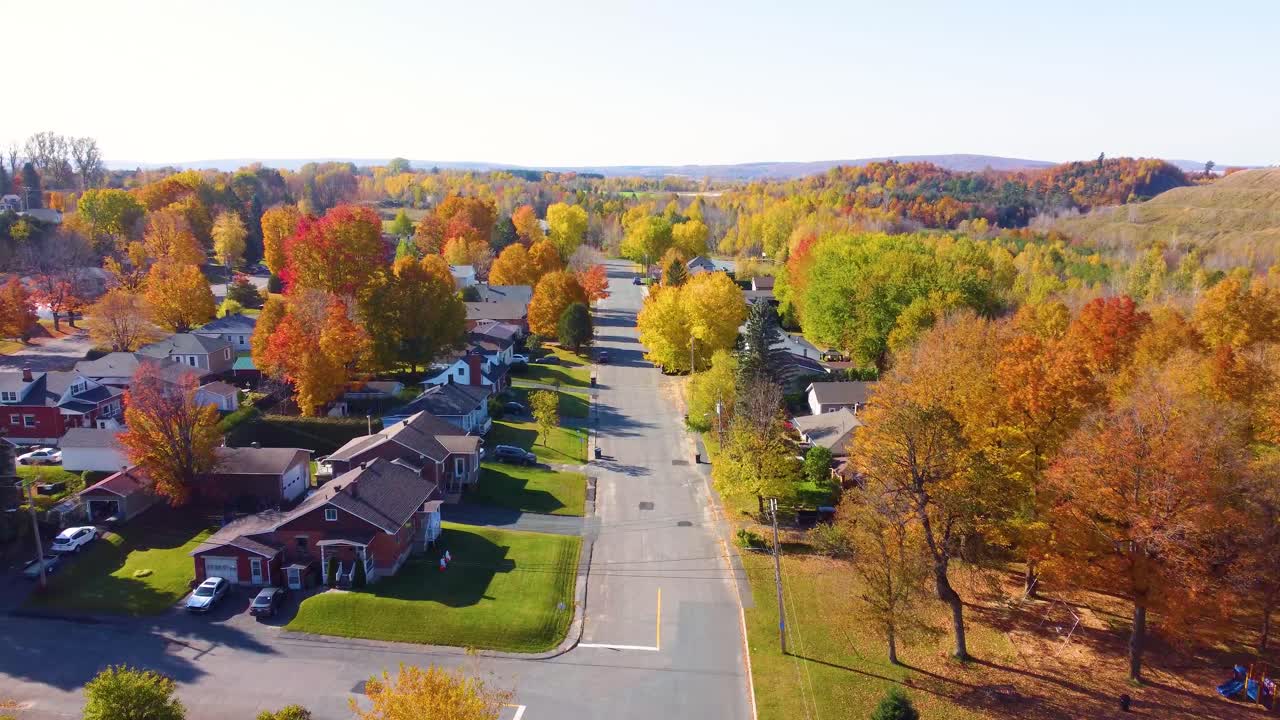 timelapse volando sobre una pequeña ciudad rural en quebec durante el pico de los colores de otoño
