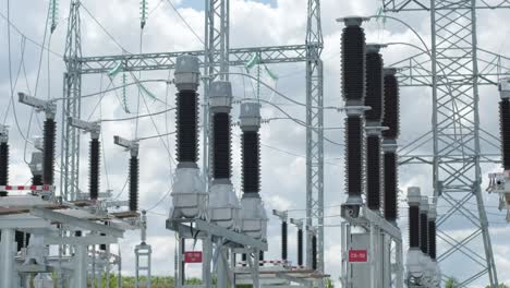 many high voltage electrical insulators in power substation against blue sky background