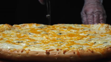 cutting a large cheese pizza