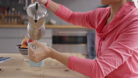 Schöne-Frau-Mit-Gemischter-Abstammung,-Die-Morgens-In-Der-Heimischen-Küche-Kaffee-Einschenkt