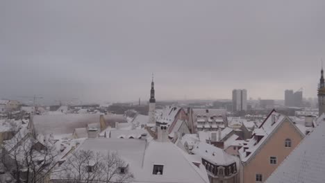 panning top view of tallinn old town during moody cloudy day in winter with snow covering the roofs