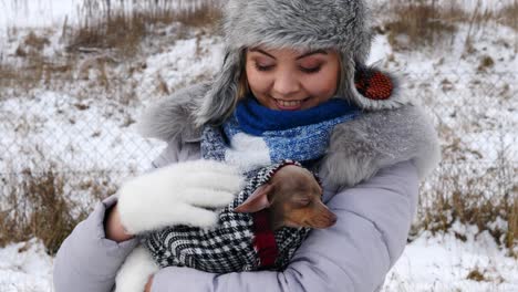 woman playing with her little dog outside winter