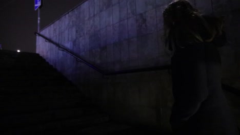 girl walking out from the underground passage in the night