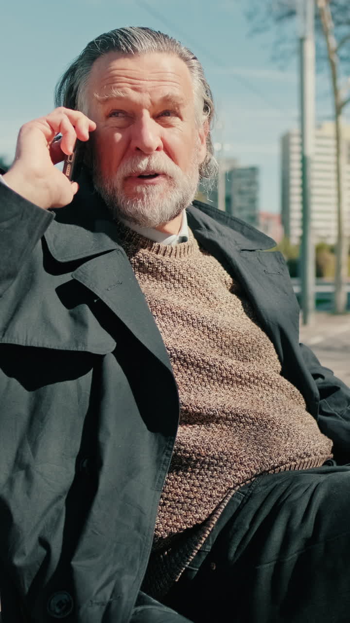 Elderly Man Talking On Phone In City Park