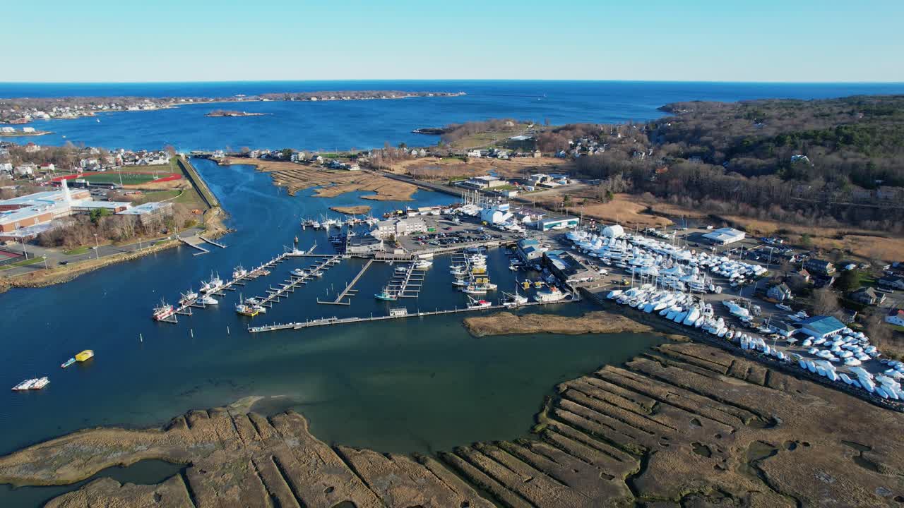 Drönarvy över en marina full av båtar och ett båtvarv i Gloucester, Massachusetts, USA. Framåtriktad flygbild.