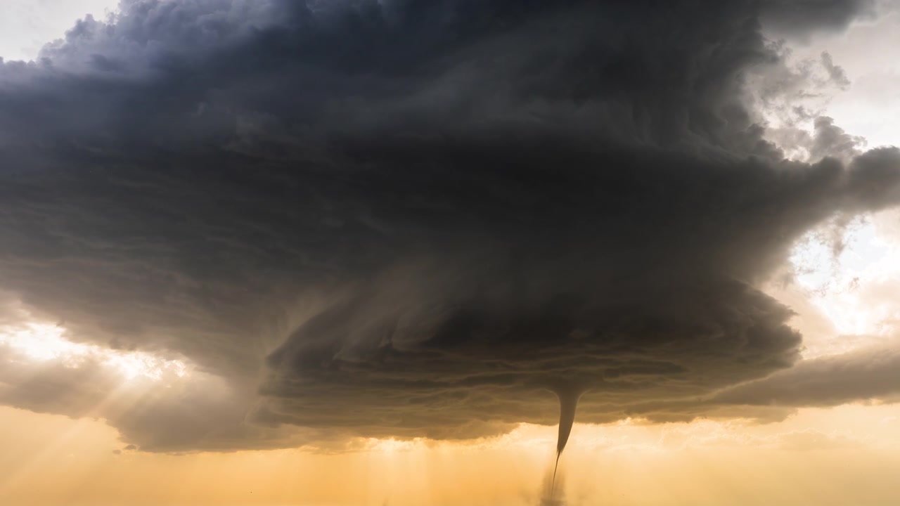 En tornado viser sig under en hvirvlende, voldsom tordenstorm i dramatisk vejr.