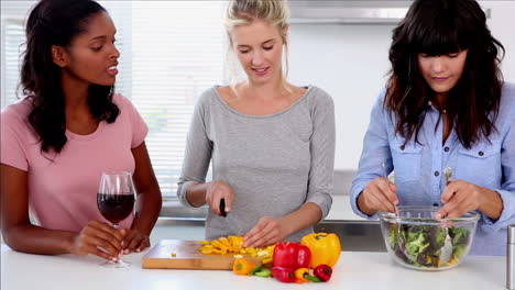 attractive friends preparing salad in the kitchen