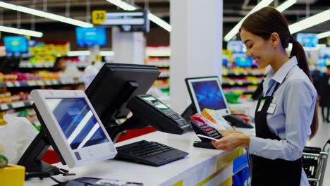 a smiling woman cashier working at a supermarket checkout