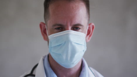 portrait of caucasian male doctor wearing face mask