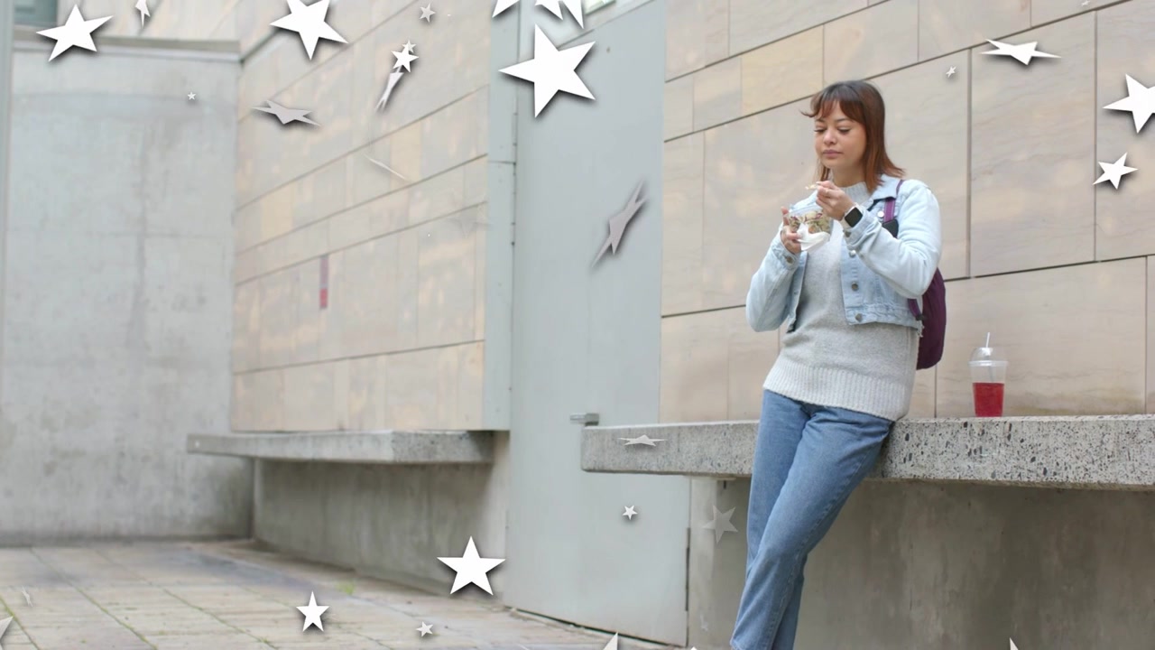 Donna in cortile che prende uno spuntino da un contenitore per il cibo per la pausa, con stelle animate che fluttuano attraverso l'inquadratura.