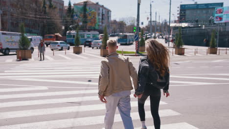 modern couple in the street. urban lifestyle. people emotionally walking on the video. girl jumping at her boyfriend while walking through the street. aerial view