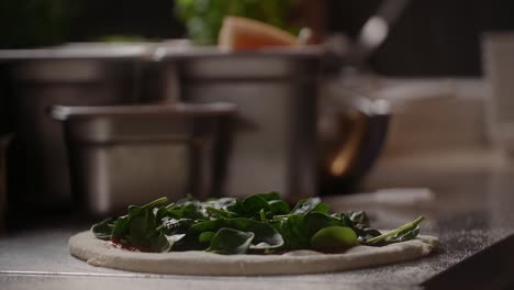 chef preparing spinach pizza