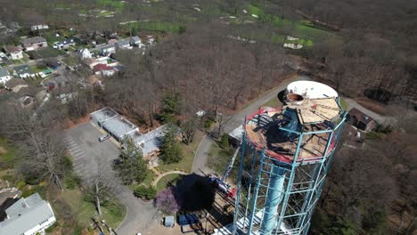 Una-Vista-Aérea-De-Una-Torre-De-Agua-Que-Se-Está-Desmantelando-En-Un-Día-Soleado-En-Long-Island,-Nueva-York