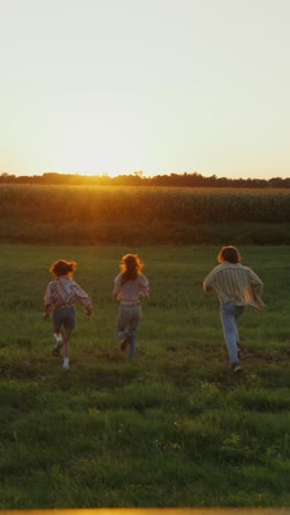 friends running in a field at sunset