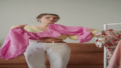 female fashion blogger demonstrating pink blouse during content recording