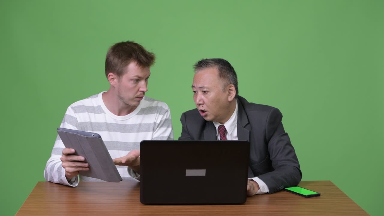 성숙한 일본 사업가와 젊은 스칸디나비아 사업가가 함께 일하고 있습니다.