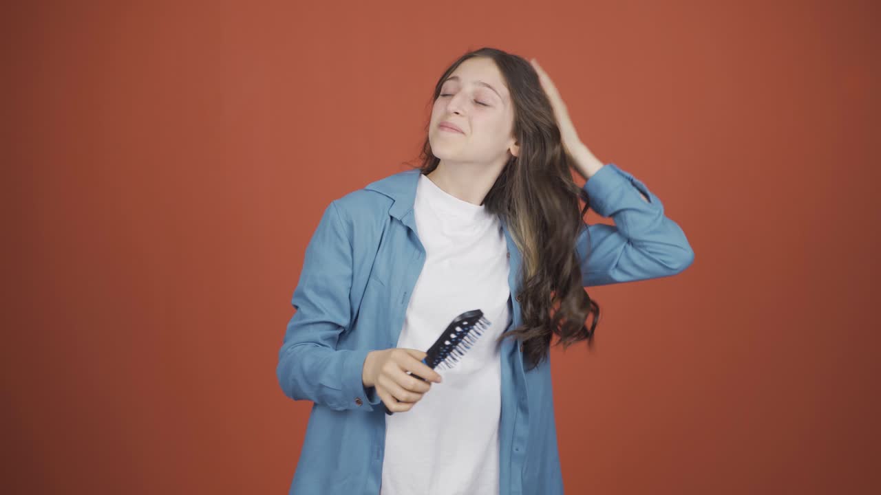 mujer joven peinándose el cabello.