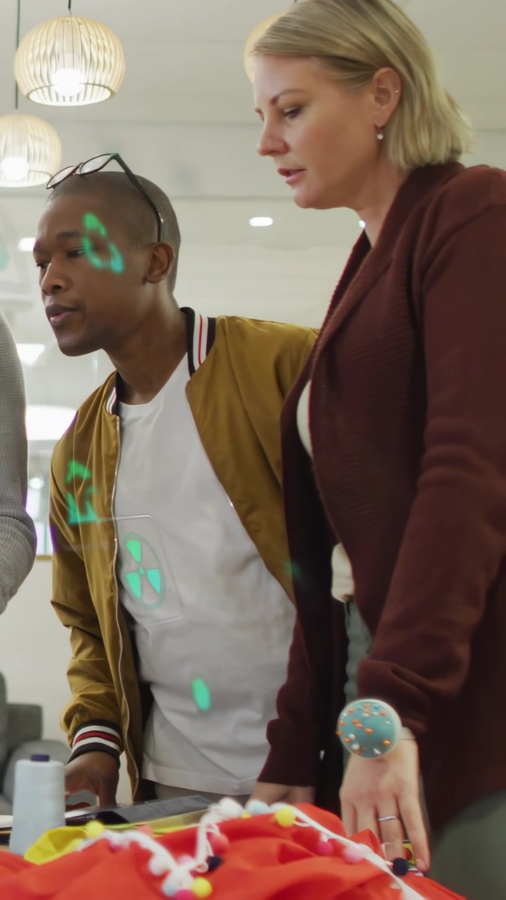 Vertical video: Designers checking red fabric after prototype set, green AR marking trim for design
