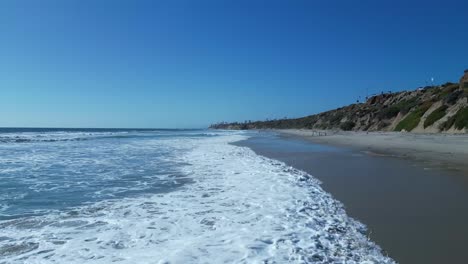 drone flight over ocean waves on a beautiful sunny day in carlsbad california