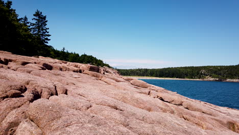 rocky shoreline of acadia national park, view of sand beach in distance, static shot