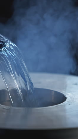 pouring liquid into a metal container with vapor/smoke