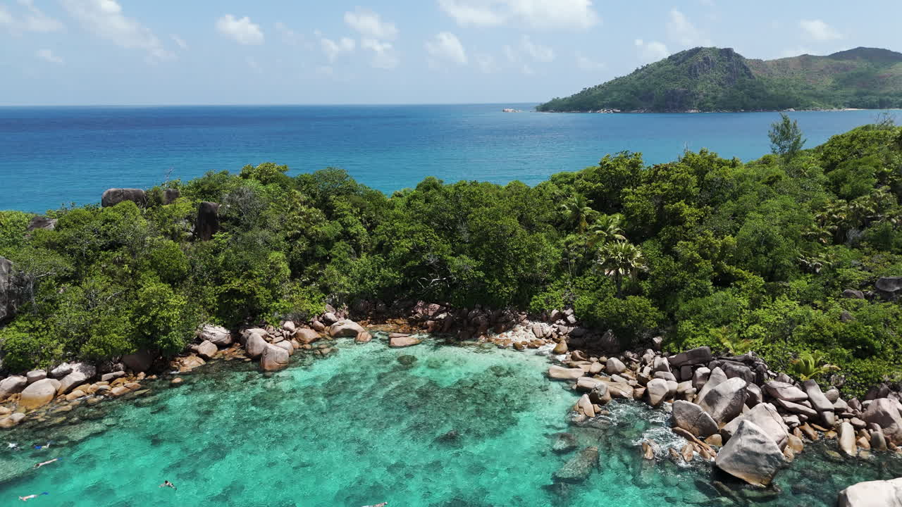 Ripresa drone di una spiaggia rocciosa su un'isola tropicale che rivela l'oceano sullo sfondo