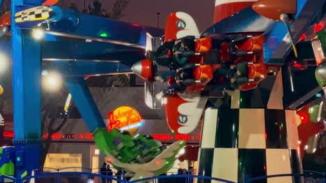 airplanes down at fantasilandia amusement park, johnny rockets sign at night, santiago, chile.