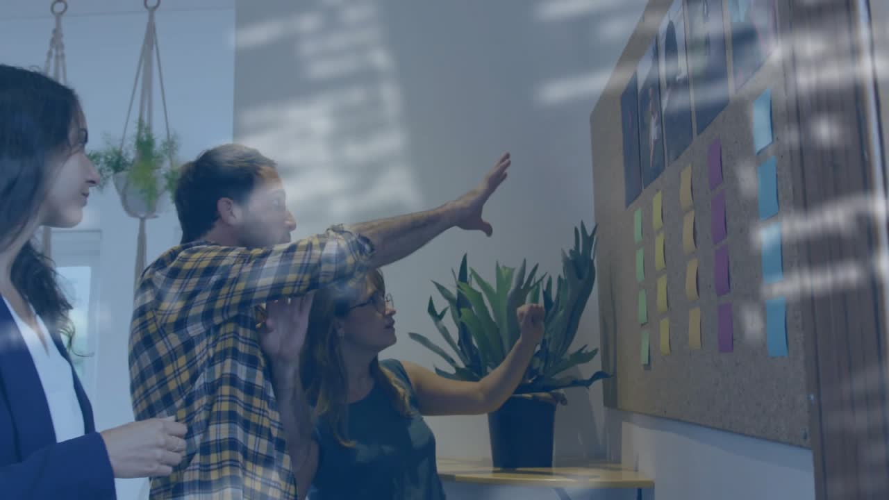 Woman reaching to place sticky note, team joining sorting corkboard under code overlay for business