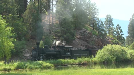 a steam train moves around a curve in the rocky mountains 1