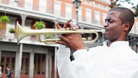 black man plays a trumpet in the street