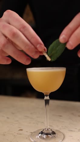 bartender preparing a cocktail with mint garnish