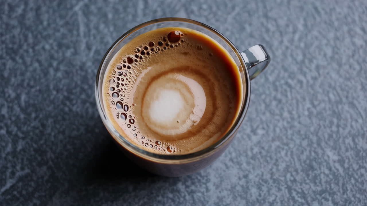 A close-up, top-down view of a cup of coffee with latte art