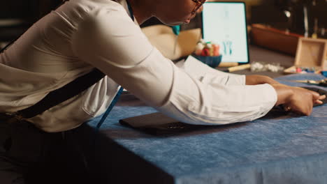 Seamstress-preparing-fabric-on-table