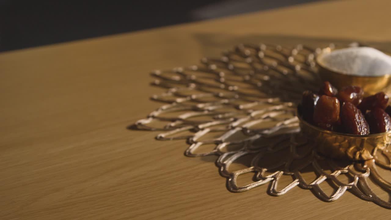 eid 6을 축하하는 이슬람 가정의 테이블 위에 물 한 잔이 있는 날짜 그릇